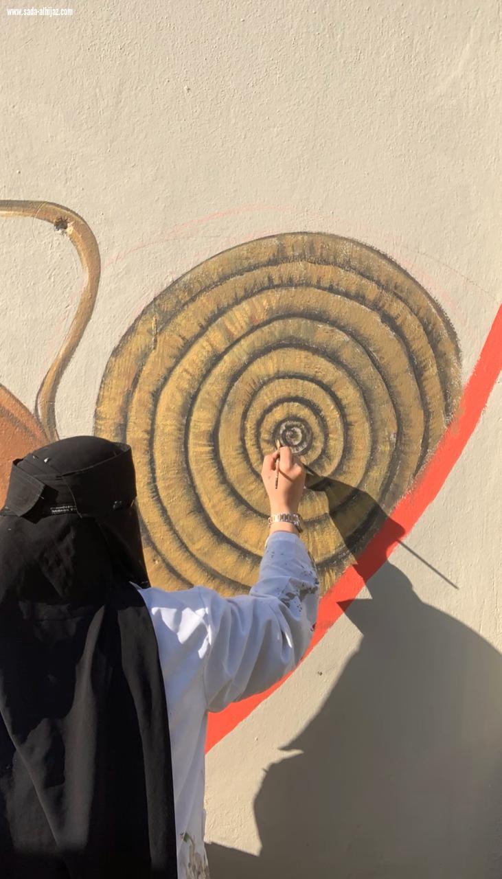 فريق كلمات وألوان يبدع في رسم جدارية مهرجان البن