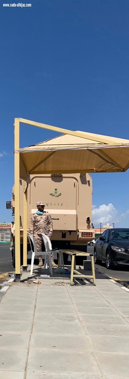 الروقي يوزع المضلات ليقي رجال الأمن من حرارة الشمس